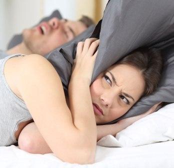 donna a letto disturbata da un uomo che dorme russando